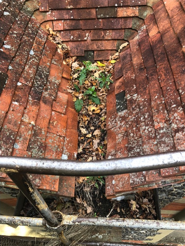 Heavily blocked roof valley shown before gutter clearance service